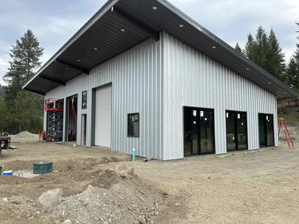 A custom 75-by-50-foot commercial steel structure building with a roll-up service door and full-height storefront glazing.