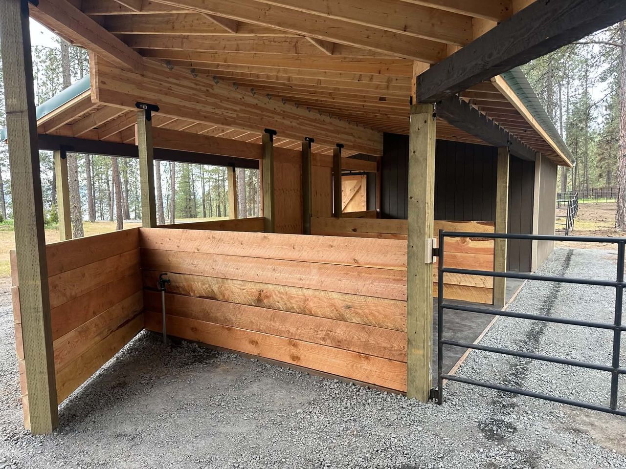 Custom timber horse stall and hay shed built with an integrated tack room, hay storage, and custom wood sliding barn doors.