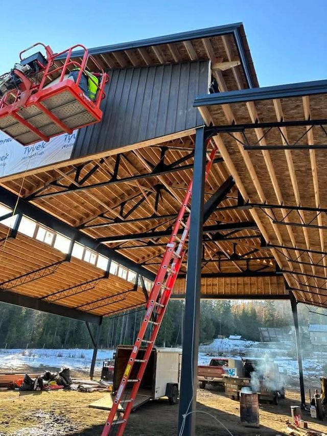Interior construction view of a hybrid building structural layout featuring a heavy steel framework paired with dimensional wood roof purlins.
