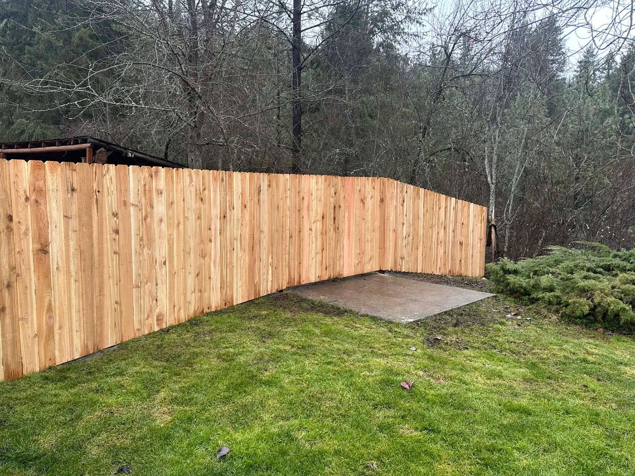 A newly installed six-foot-tall wooden privacy fence providing clean lines and residential perimeter security.